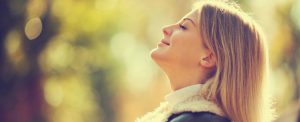 Young happy woman enjoying fresh air in autumn, intentionally toned.