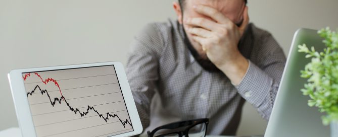 Depressed businessman leaning head below bad stock market